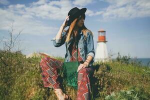 jung Frau im Natur, Leuchtturm Denim Jacke, schwarz Hut, Sommer, stilvoll Zubehör foto