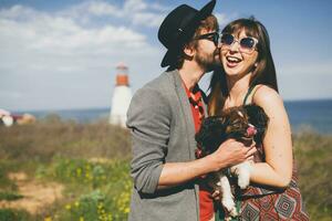 schön lächelnd jung stilvoll Hipster Paar im Liebe Gehen mit Hund im Landschaft foto