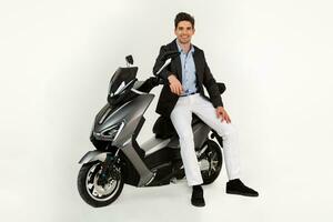gut aussehend Mann Reiten auf elektr Motorrad Roller isoliert auf Weiß Studio Hintergrund foto