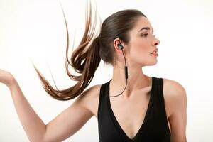 attraktiv Frau im Joggen schwarz oben Hören zu Musik- auf Kopfhörer foto