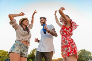 Unternehmen von freunde haben Spaß zusammen im Park Hören zu Musik- foto