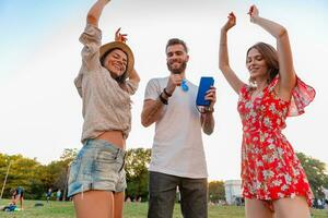 Unternehmen von freunde haben Spaß zusammen im Park Hören zu Musik- foto