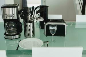 Küche Tabelle im Essen Zimmer Haushalt Haushaltsgeräte, Toaster, Kaffee Maschine foto