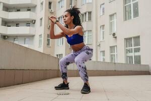 attraktiv schwarz afrikanisch amerikanisch Frau im Sport Fitness Outfit auf Dach Herstellung Arbeit aus foto