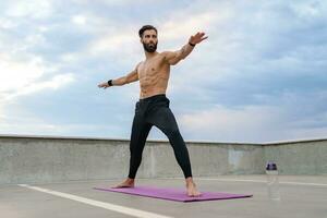 attraktiv gutaussehend Mann mit sportlich stark Körper tun Morgen Yoga Asana draußen foto