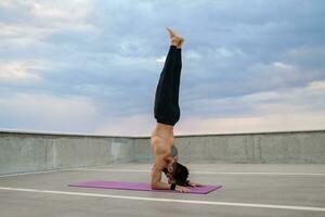 attraktiv gutaussehend Mann mit sportlich stark Körper tun Morgen Yoga Asana draußen foto