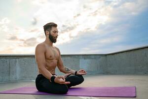 attraktiv gutaussehend Mann mit sportlich stark Körper tun Morgen Yoga dzen Meditation foto