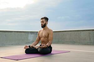 attraktiv gutaussehend Mann mit sportlich stark Körper tun Morgen Yoga dzen Meditation foto