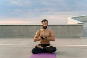 attraktiv gutaussehend Mann mit sportlich stark Körper tun Morgen Yoga dzen Meditation foto