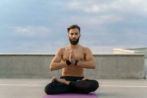 attraktiv gutaussehend Mann mit sportlich stark Körper tun Morgen Yoga dzen Meditation foto