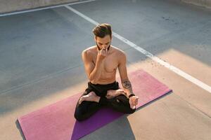 attraktiv gutaussehend Mann mit sportlich stark Körper tun Morgen Yoga dzen Meditation foto