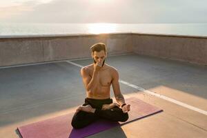 attraktiv gutaussehend Mann mit sportlich stark Körper tun Morgen Yoga dzen Meditation foto