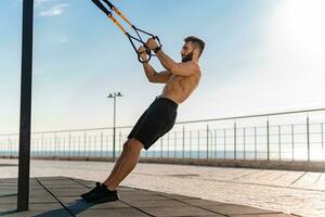 attraktiv gutaussehend Mann mit nacktem Oberkörper mit sportlich stark Körper auf Morgen Fitness trainieren Übung foto