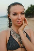 jung schön blond Frau Sonnenbaden auf Sand Strand im Bikini Schwimmen Anzug, Jahrgang Halskette foto