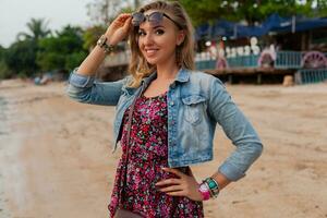 stilvoll Frau im Sommer- Kleid Ferien Gehen auf Strand mit Sonnenbrille foto