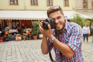 jung gut aussehend Hipster Mann Gehen mit Foto Kamera