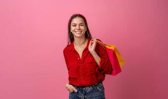 spanisch schön Frau im rot Hemd lächelnd halten halten Einkaufen Taschen foto