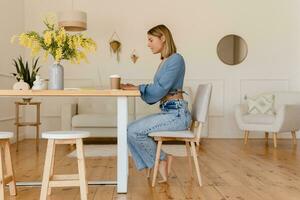 jung ziemlich stilvoll Frau Arbeiten Fernbedienung beim Zuhause beim Tabelle Arbeitsplatz, Schüler Bildung foto