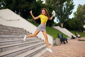 jung stilvoll Frau haben Spaß im Stadt Park, Sommer- Stil Mode Trend foto