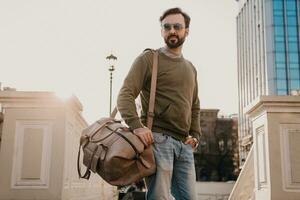 Hipster Mann Gehen im Straße mit Tasche foto