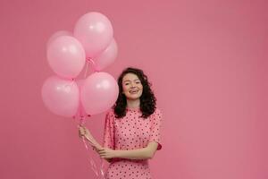 ziemlich jung Frau posieren isoliert auf Rosa Studio Hintergrund mit Rosa Luft Ballons foto