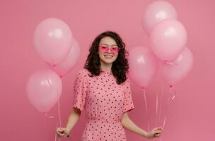 ziemlich jung Frau posieren isoliert auf Rosa Studio Hintergrund mit Rosa Luft Ballons foto