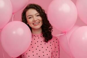 ziemlich jung Frau posieren isoliert auf Rosa Studio Hintergrund mit Rosa Luft Ballons foto