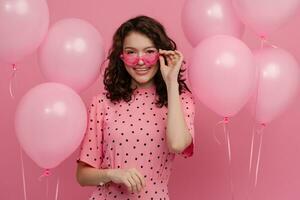 ziemlich jung Frau posieren isoliert auf Rosa Studio Hintergrund mit Rosa Luft Ballons foto