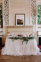 das Präsidium des Brautpaares im Festsaal des Restaurants ist mit Kerzen und Grünpflanzen geschmückt