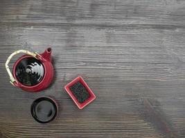 roter Tee auf einem Holztisch. rote Teekanne, Tasse und chinesischer Tee. Draufsicht mit Kopienraum foto