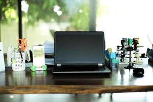 Arbeit von zu Hause aus Konzept. Nahaufnahme Laptop auf dem Holztisch, umgeben von den Büropapieren mit unscharfem Hintergrund foto