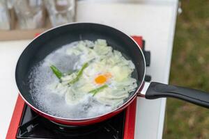 ein schwenken zu Kochen Eier auf ein Camping Gas Herd foto