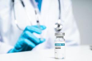 Der Arzt hält eine Spritze mit Covid-19-Impfstoffen in einer Glasflasche. Covid-19-Coronavirus-Behandlungskonzept.