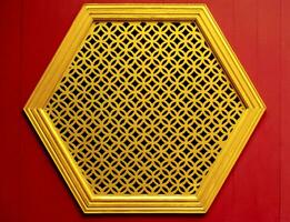 Gold Hexagon Schablone Fenster auf das Holz rot Mauer Chinesisch Stil foto