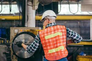 Rückansicht-Ingenieur-Arbeiter, der an der Drehmaschine arbeitet, foto