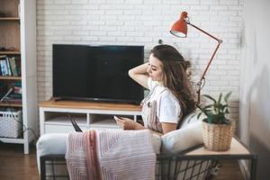 junge tausendjährige frau, die zu hause online einkauft. foto