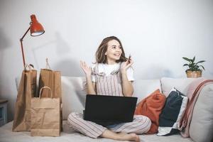 junge tausendjährige frau, die zu hause online einkauft. foto