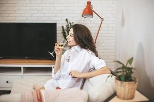 junge Frau mit einem Glas Wein zu Hause. foto