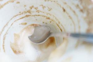 weiße Tasse mit Kaffeeresten auf dem Tisch foto