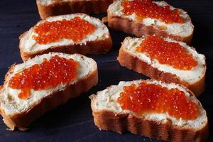 Sandwiches mit rotem Kaviar auf dunklem Hintergrund