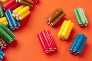 bunte Süßigkeiten auf orangem Hintergrund foto