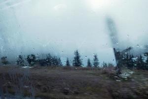 Wasserdampftropfen auf transparentem Fenster auf dem Weg zum Wald foto