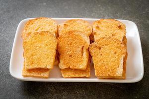 gebackenes knuspriges Brot mit Butter und Zucker auf Teller foto