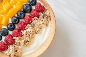 hausgemachte Joghurt-Bowl mit Himbeere, Heidelbeere, Mango und Müsli - gesunder Food-Style foto