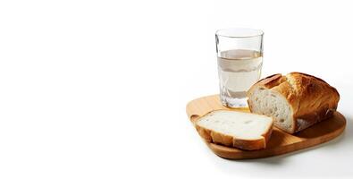 Weiß Brot und Wasser im ein Glas auf ein hölzern Tafel mit Raum zum Text. Glas von Wasser und Brot auf ein Weiß Hintergrund. foto