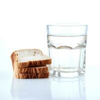 ein Glas von Wasser und ein Kruste von Weiß Brot auf ein Weiß Hintergrund. foto