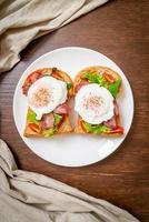 Vollkornbrot geröstet mit Gemüse, Speck und Ei oder Ei Benedikt zum Frühstück foto