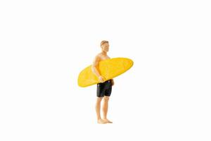 Miniatur Menschen Mann halten ein Gelb Surfbrett, isoliert auf Weiß Hintergrund mit Ausschnitt Pfad foto