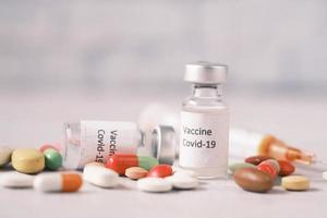 Nahaufnahme von Coronavirus-Impfstoff, Spritzen- und Pillentabelle
