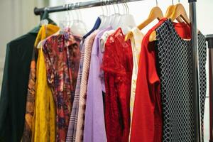 viele anders farbig Damen Kleider auf Kleiderbügel im ein Geschäft foto
